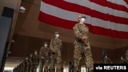 Personal militar usa máscaras contra el contagio de coronavirus en la preparación de una ceremonia de graduación que se celebró en abril de 2020 en una base castrense en San Antonio, Texas, EE.UU.