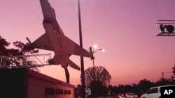 FILE - A mock F-16 fighter jet is silhouetted against the sky at sunrise at Moody Air Force Base at Valdosta, Ga., where two Afghan students who were receiving training went missing this week, Dec. 11, 2015.