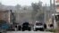 Security officials investigate the scene of a suicide car bomb attack, which killed and injured several people at the National Directorate of Security in Jalalabad, Afghanistan, February 24, 2013. 