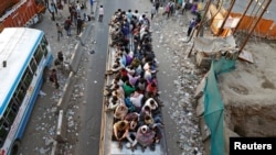 Migrant workers travel on a crowded bus as they return to their villages, during a 21-day nationwide lockdown to limit the spreading of coronavirus, in Ghaziabad, on the outskirts of New Delhi, India.