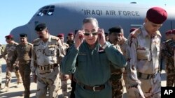 El Ministro de Defensa de Irak, Khaled al-Obeidi (centro) llega a una base militar en las afueras de Tikrit, 180 kms al norte de Bagdad. Al-Obeidi dijo que ISIS no tiene capacidades químicas, y sus ataques mas bien intentan afectar la moral de las tropas que los combaten.