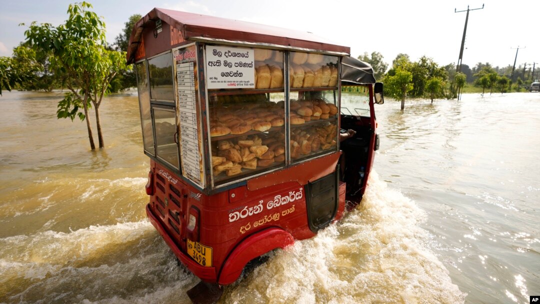 Seorang penjual roti Sri Lanka mengendarai gerobaknya melalui daerah yang dilanda banjir di Gampaha, 20 kilometer sebelah timur Kolombo, Sri Lanka, Rabu, 10 November 2021. 