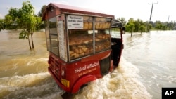 Seorang penjual roti Sri Lanka mengendarai gerobaknya melalui daerah yang dilanda banjir di Gampaha, 20 kilometer sebelah timur Kolombo, Sri Lanka, Rabu, 10 November 2021. 