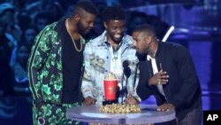 In this Saturday, June 16, 2018, photo, Winston Duke, from left, Chadwick Boseman and Michael B. Jordan accept the award for best movie for "Black Panther" at the MTV Movie and TV Awards in Santa Monica, Calif. 