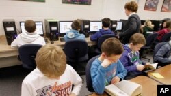 Niños trabajan en las computadoras de la escuela. 