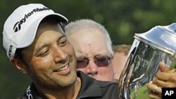 Arjun Atwal, of India, holds the Sam Snead Cup on the 18th green after winning the Wyndham Championship golf tournament in Greensboro, N.C, 22 Aug 2010