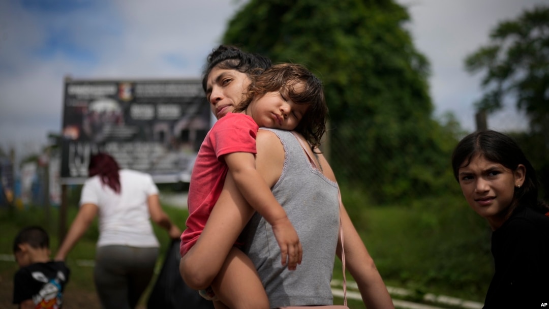 La migrante venezolana Naiber Zerpa sostiene a su hijo Mathías Márquez cuando llegan a un campamento temporal después de cruzar caminando el Tapón del Darién desde Colombia, en Lajas Blancas, Panamá, el viernes 28 de junio de 2024.