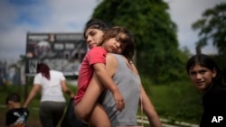 La migrante venezolana Naiber Zerpa sostiene a su hijo Mathías Márquez cuando llegan a un campamento temporal después de cruzar caminando el Tapón del Darién desde Colombia, en Lajas Blancas, Panamá, el viernes 28 de junio de 2024.
