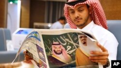 Seorang pria membaca koran dengan gambar Raja Saudi Salman (kanan) dan Putra Mahkota Mohammed bin Salman, di ruang pers menjelang KTT Arab dan Islam di Mekkah, Arab Saudi, 30 Mei 2019.
