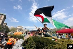 Seorang mahasiswa mengibarkan bendera Palestina dalam aksi demonstrasi pro-Palestina di kampus Universitas Columbia di kota New York, 29 April 2024 (foto: ilustrasi).