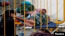 FILE - Migrant workers rest at a swab isolation facility as they wait for their test results at a dormitory, amid the coronavirus disease (COVID-19) outbreak in Singapore, May 15, 2020. 