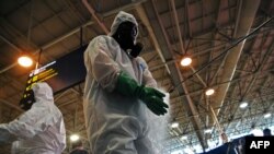 A soldier disinfects his gloves after carrying out a disinfection operation against COVID-19 at Tom Jobim Galeao International Airport in Rio de Janeiro, Brazil, on April 24, 2020. 