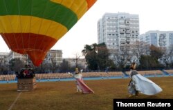 Dos de los Reyes Magos caminan hacia el globo aerostático que los llevará a sobrevolar la ciudad para saludar a los niños en Sevilla, España, en la víspera de la Epifanía (6 enero). Martes 5 de enero de 2021.