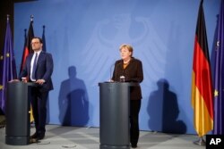 German Chancellor Angela Merkel, right, and Health Minister Jens Spahn brief the media after a virtual meeting with federal state governors at the chancellery in Berlin, Germany, March 30, 2021.