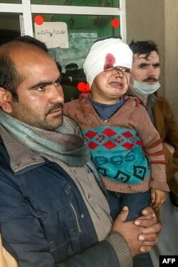 A Pakistani Kashmiri carries an injured child at a hospital following cross-border shelling between Pakistani and Indian forces in Tehjain village at the Line of Control in Neelum Valley, Pakistan-administered Kashmir, Nov. 13, 2020.
