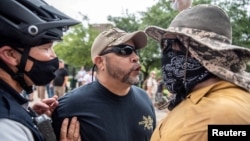 Demonstranti i kontrademonstranti na protestu protiv obaveze nošenja maske radi spriječavanja pandemije koronavirusa u Austinu u Texasu, 28. juna 2020. (Foto: Reuters)