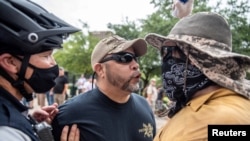 Two protesters at a protest against mandates to wear masks amid the coronavirus outbreak, Austin, Texas, June 28, 2020. 