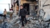 İsrail'in Refah saldırılarında ağır hasar göre bir binanın enkazında yürüyen insanlar - 11 Şubat 2024.