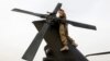 FILE - A US Army soldier performs a system check on a helicopter at the beginning of her shift in Logar province, eastern Afghanistan, Nov. 21, 2011. 