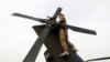 FILE - A U.S. Army soldier performs a system check on a helicopter at the beginning of her shift in Logar province, eastern Afghanistan, Nov. 21, 2011. 