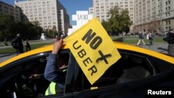 FILE - A taxi driver holds a flag reading "No more Uber" during a nationwide strike to protest against Uber Technologies in Santiago, Chile.