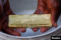 A worker washes off excess impurities during a gold smelting process at a facility in Accra, Ghana August 22, 2024. (REUTERS/Francis Kokoroko)