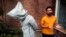 Saud Baloch, 28, a fine art artist, stands near his sculpture called "No Fear" during an interview at the National College of Arts in Lahore, Pakistan, March 22, 2013