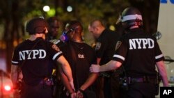 New York Police Department officers escort a protester after he was arrested at a rally calling for justice over the death of George Floyd, in the Brooklyn borough of New York, June 3, 2020. 