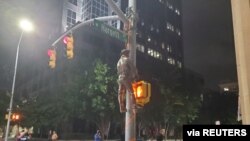 A Confederate statue is seen hanging on a street post in Raleigh, North Carolina, U.S. June 19, 2020 in this picture obtained from social media. 