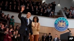 Presiden Amerika, Barack Obama dan ibu negara Michelle Obama melambaikan tangan kepada para hadirin seusai menyampaikan sambutan di Belfast Waterfront Hal, Belfast, Irlandia Utara, (17/6). Presiden Obama mengunjungi Irlandia Utara untuk menghadiri KTT G-8 yang diselenggarakan selama dua hari di Enniskillen.