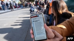 An asylum seeker shows an updated message on the CBP One app mentioning that all appointments have been canceled before crossing through El Chaparral port in Tijuana, Baja California state, Jan. 20, 2025.