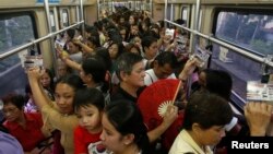 FILE - Commuters ride a train during rush hour on Southeast Asia's first light rail transit network, which is 29-years-old, in Manila, Oct. 10, 2013. The Philippines is about to spend $169 billion on infrastructure, including railways and an airport terminal.