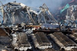 Charred remains of a warehouse and new cars are left burned after an explosion at a warehouse in northeastern China's Tianjin municipality, Aug. 13, 2015.