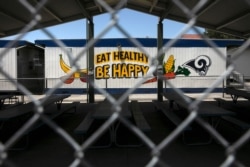 FILE - The cafeteria area of an elementary school is seen through a fence in Los Angeles, July 17, 2020.