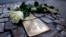 A rose lies beside a memorial stone commemorating Holocaust victim Rosa Lesser in front of her former home, Berlin, Nov. 9, 2013.