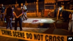 FILE - Bangladeshi policemen investigate at the site of attack on Bangladeshi-American blogger Avijit Roy, in Dhaka, Bangladesh, Feb. 26, 2015.