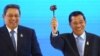 Cambodian Prime Minister Hun Sen (R) waves a gavel after taking over the ASEAN chairmanship from Indonesian President Susilo Bambang Yudhoyono during the handover ceremony at the closing session of ASEAN Summit and Related Summits in Nusa Dua, Bali Novemb