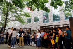 FILE - An Immigration and Customs Enforcement official assists people waiting to enter immigration court in Atlanta, June 12, 2019.