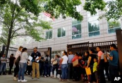 An Immigration and Customs Enforcement official aid people waiting to enter immigration court in Atlanta, June 12, 2019. U.S. authorities are fast-tracking families' cases to discourage many from making the trip to seek refuge in the United States.