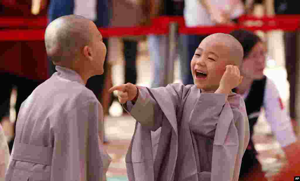 Two boys laughs at each other after shaving their heads during a service to celebrate Buddha&#39;s upcoming 2,560th birthday on May 14, at Jogye Temple in Seoul, South Korea.