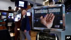 A trader passes a hand sanitizing station on the floor of the New York Stock Exchange, March 3, 2020. Federal Reserve Chairman Jerome Powell noted that the coronavirus "poses evolving risks to economic activity." 