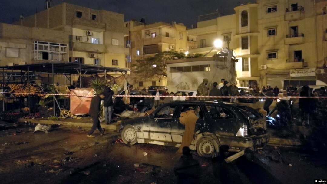 People gather at the site of twin car bombs in Benghazi, Libya, Jan. 23, 2018.