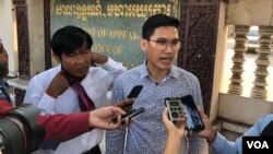 Yeang Sothearin dan Uon Chhin, mantan wartawan Radio Free Asia, berbicara kepada para wartawan di luar gedung pengadilan, 23 Desember 2019. (Foto: Tum Malis/VOA)