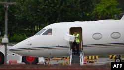 A worker unloads a box from Tesla CEO Elon Musk’s plane before he boards it to take off from Beijing Capital International Airport, in Beijing on April 29, 2024.