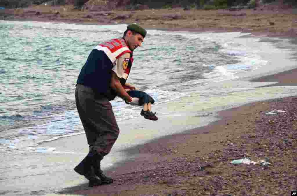 Polisi paramiliter di pantai dekat Bodrum, Turki, menggendong mayat anak migran yang kemudian diketahui bernama Aylan Kurdi, yang merupakan salah satu penumpang kapal migran yang terbalik.