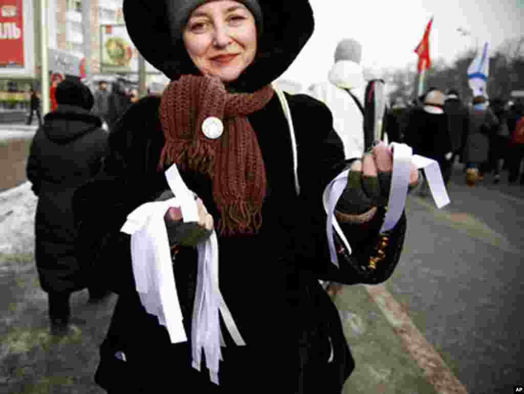 A protester hands out white ribbons at Saturday’s protests. The ribbons have become a symbol of fair and honest elections, February 4, 2012. (VOA - Y. Weeks)