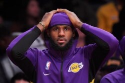 FILE - Los Angeles Lakers forward LeBron James sits on the bench during the first half of a preseason NBA basketball game against the Golden State Warriors, Oct. 14, 2019, in Los Angeles.