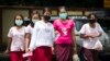 Women wear masks to protect against the swine flue virus, July.25, 2017, in Yangon, Myanmar.