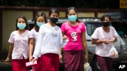 Women wear masks to protect against the swine flue virus, July.25, 2017, in Yangon, Myanmar.