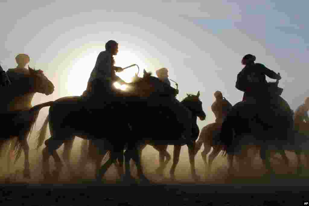 October 27: Horsemen compete during a Buzkashi game in Kabul. The sport is played between two teams of horsemen competing to throw a beheaded  calf, goat, or sheep into a scoring circle.  REUTERS/Omar Sobhani